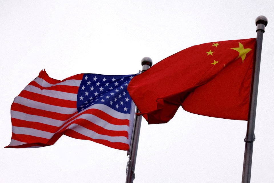 Chinese and U.S. flags flutter outside the building of an American company in Beijing