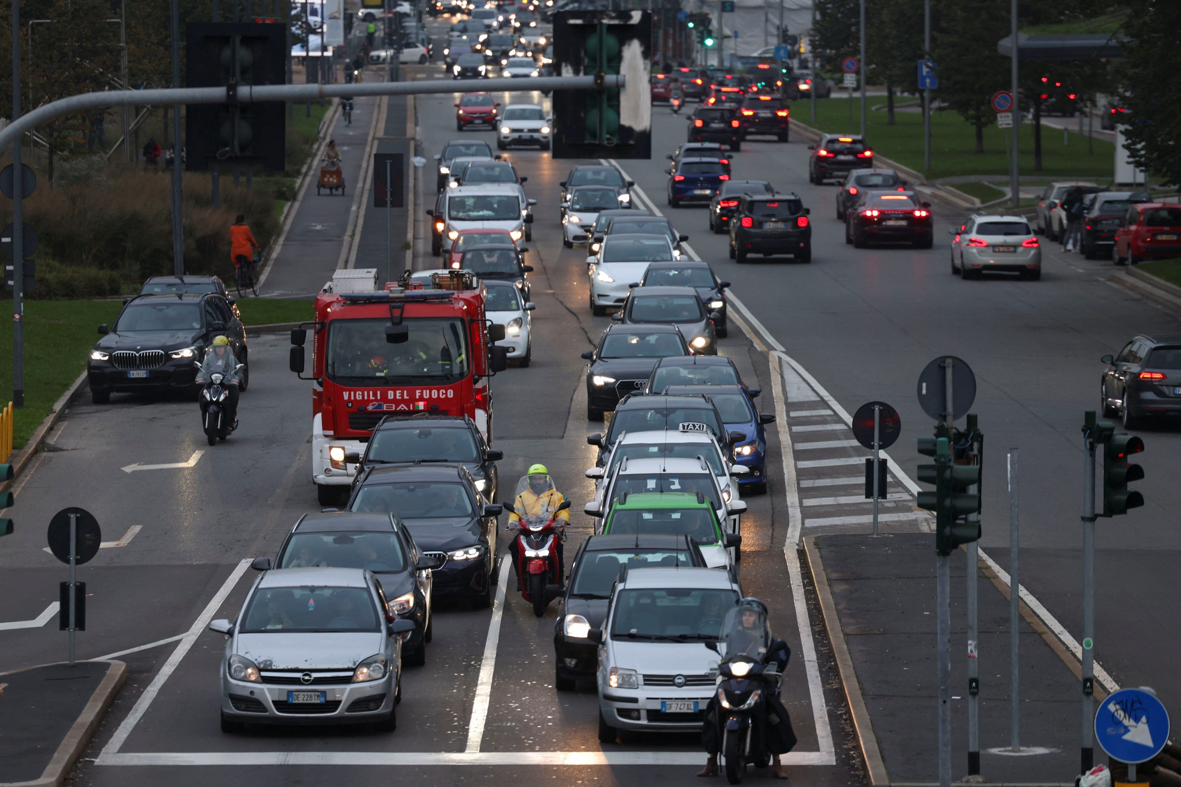 View shows cars waiting in traffic on a road in central Milan